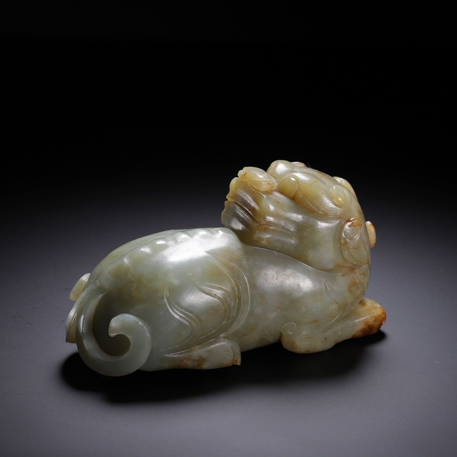 CHINESE HETIAN JADE PIXIU CARVING: Dimensions: L. 12.5 cm. W. 5 cm. H. 7 cm. Weight 730 grams. This powerful Chinese Hetian jade pixiu carving is sculpted in a recumbent pose, with sinuous body contours, a stylized mane, and a curled t
