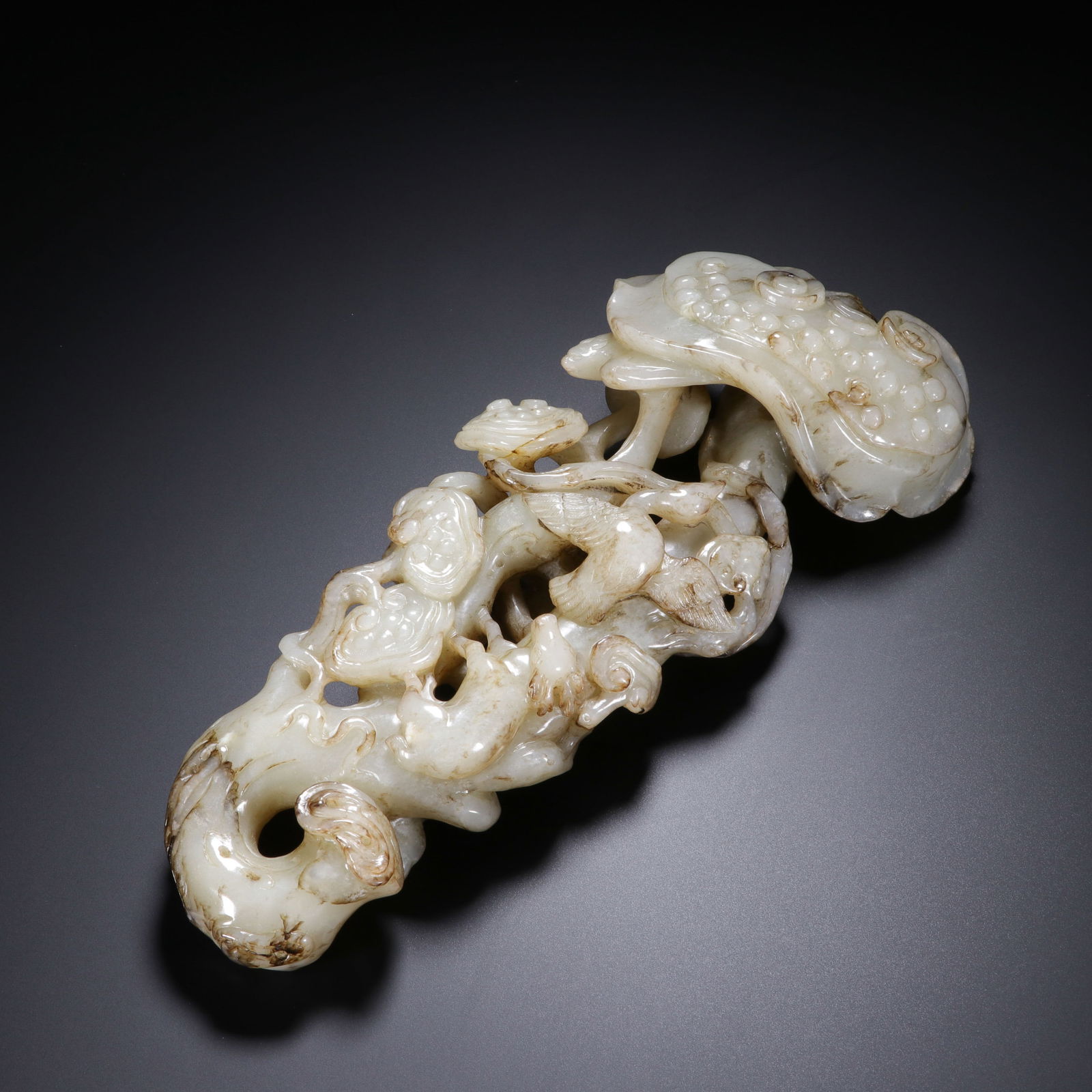 CHINESE HETIAN JADE RUYI ORNAMENT: Dimensions: L. 21 cm. W. 9 cm. This magnificent Chinese Hetian jade ruyi ornament measures 21 cm in length and 9 cm in width, crafted from translucent Hetian jade with subtle russet veining that adds