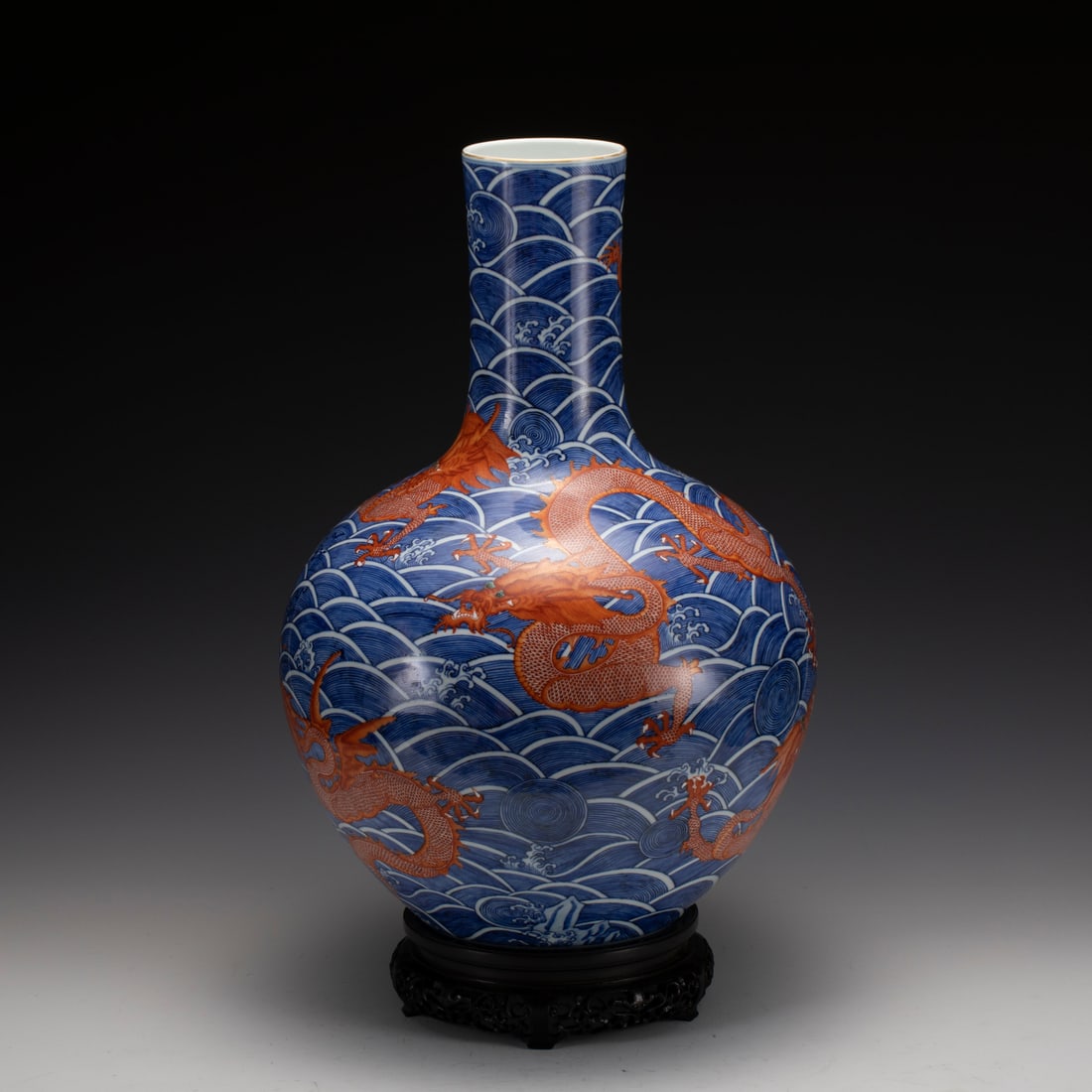 BLUE & WHITE ALUM RED DRAGON CELESTIAL VASE ON STAND: Measurements: Width: 38 cm, Height: 54.5 cm Chinese Blue and White Alum Red Dragon Porcelain Celestial vase On Carved Hardwood Stand. Potted in celestial shape vase, globular lower body,