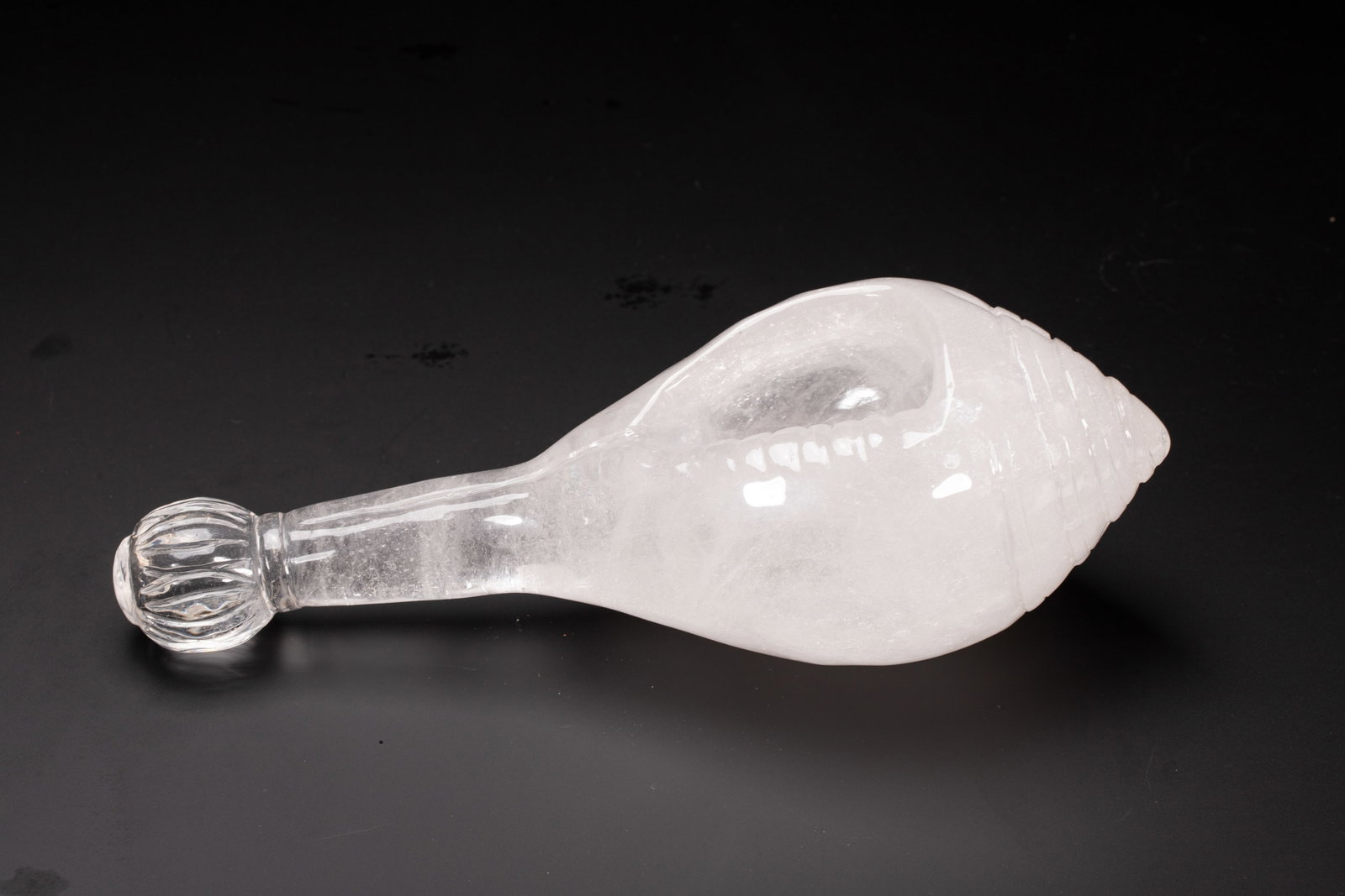 A CHINESE ROCK CRYSTAL RITUAL CONCH: Dimensions: L. 8 cm. W. 8 cm. H. 23 cm. Weight 1200 grams. This monumental Chinese ritual object is masterfully carved from a single block of clear rock crystal, shaped into a sacred dharma conch with