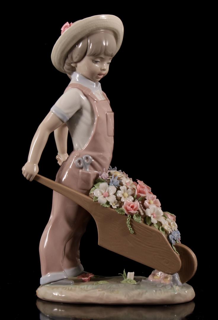 Lladro: Lladro porseleinen beeld no. 1283, Little Gardener, Carretilla Con Flores, ontwerp Francisco Catala, periode 1974, 24 cm hoog (1 bloemetje los)