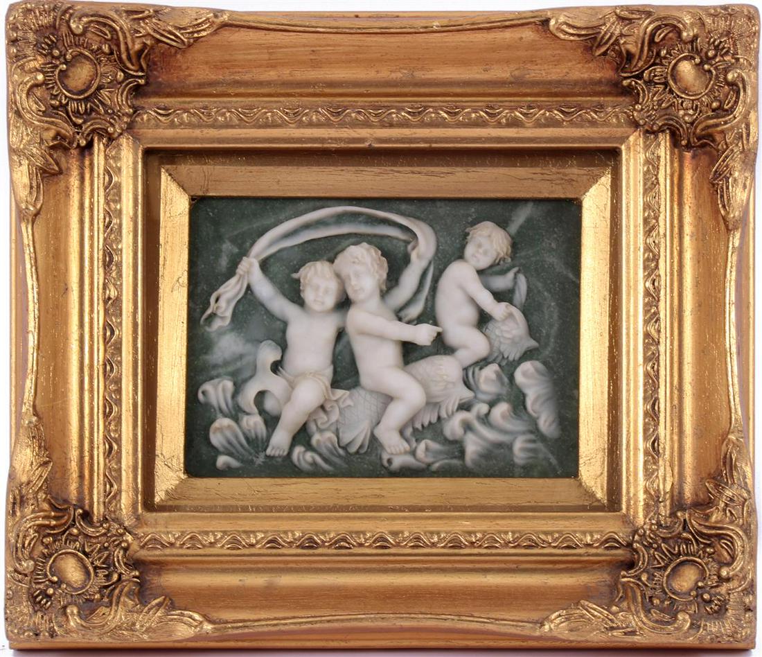 Wall decoration with alabaster depiction of playing: Wall decoration with alabaster depiction of playing putti sitting on fish behind glass in gold colored frame 25.5x30.5 cm