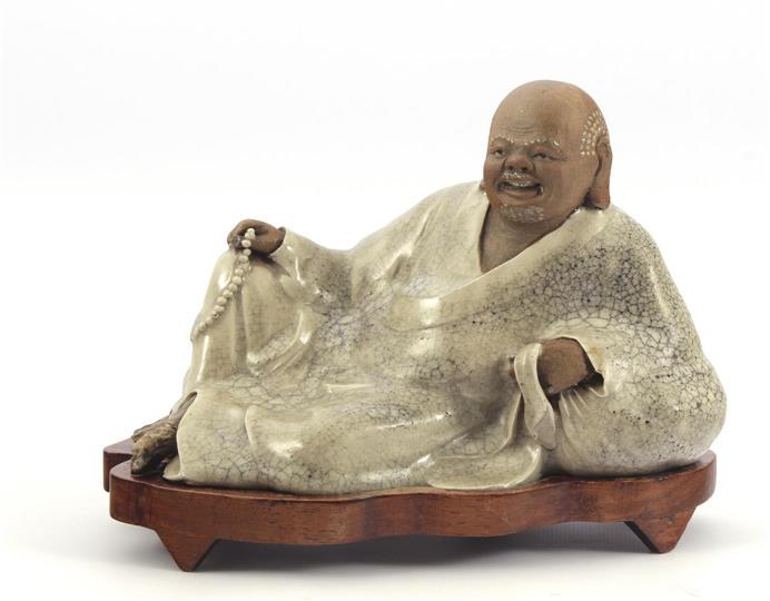 Ceramic statue: Ceramic statue of a reclining man on a wooden base, China 20th century, 15 cm high