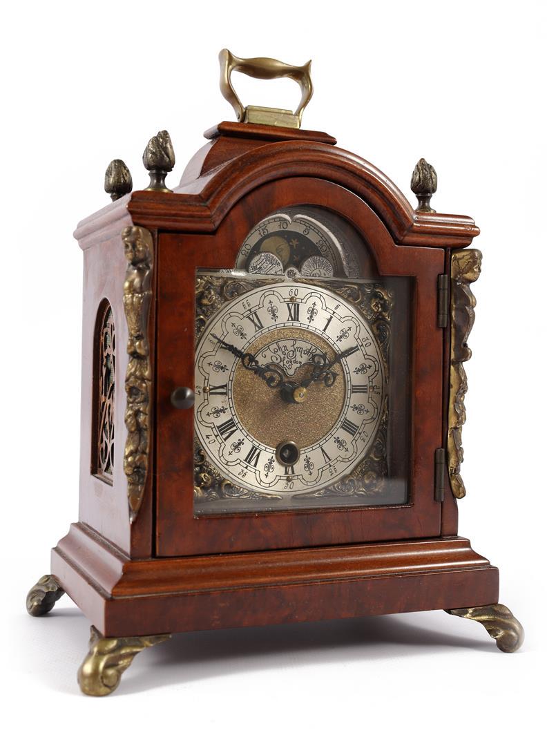 English table clock with moon phase in walnut and: English table clock with moon phase in walnut and walnut case, on cap rail 4 brass acorns and flanked by caryatids, dial with Roman numerals and John Smith address, 23.5 cm high