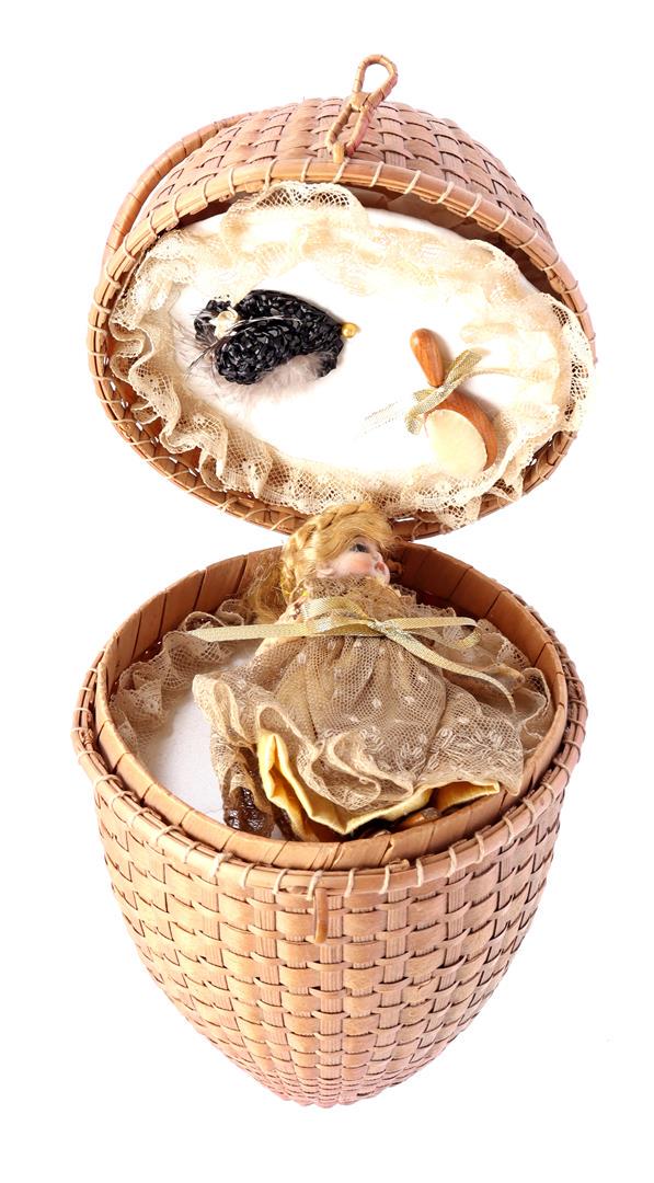 Object in the shape of a wicker egg on a ring: Object in the shape of a wicker egg on a ring, 33 cm high, inside a porcelain doll with glass eyes, ca. 1884