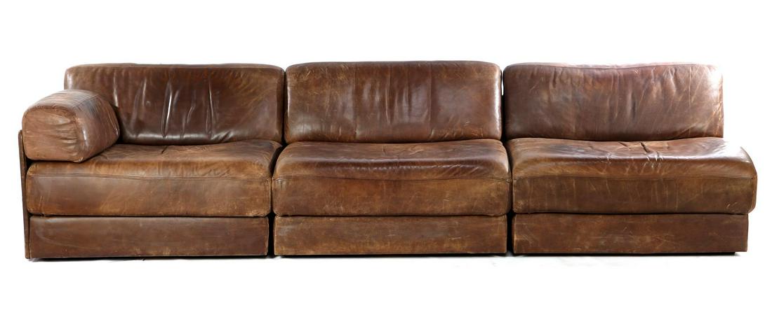 De Sede: Brown leather 3-seater De Sede (sleeping) sofa, model DS76, Switzerland, 1970s, each 91 cm wide (damaged leather)
