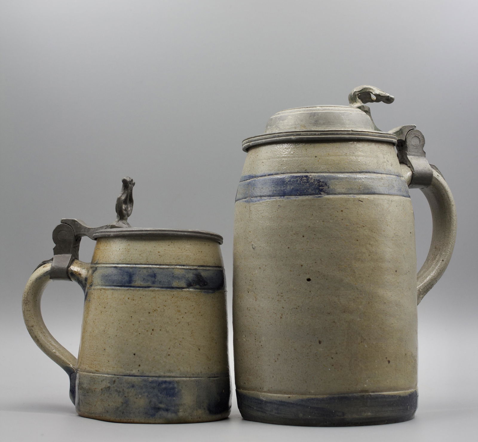 TWO DECORATED STONEWARE TANKARDS (MUGS) WITH PEWTER COVERS. (1 of 14)