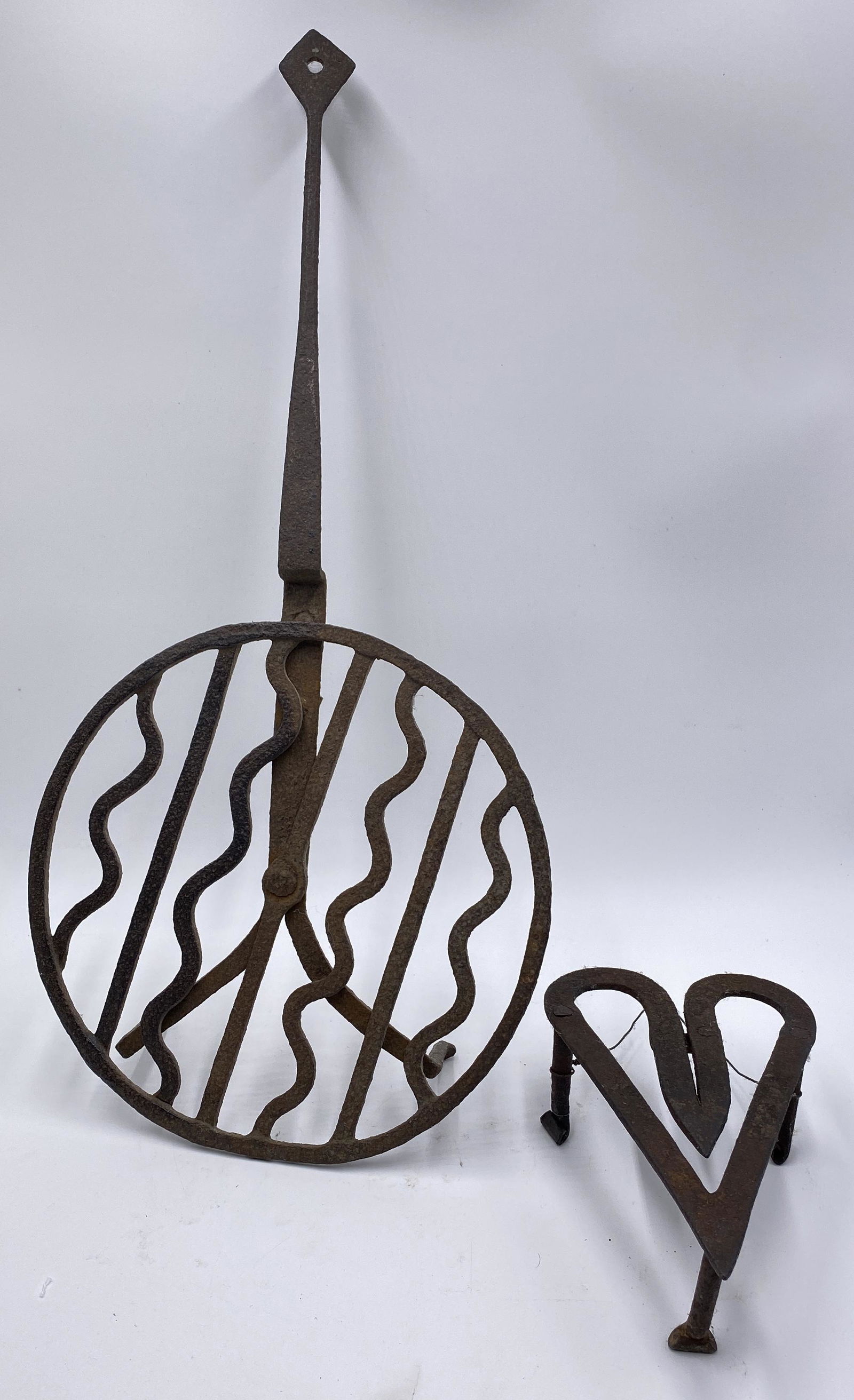TWO IRON TRIVETS. (1 of 3)