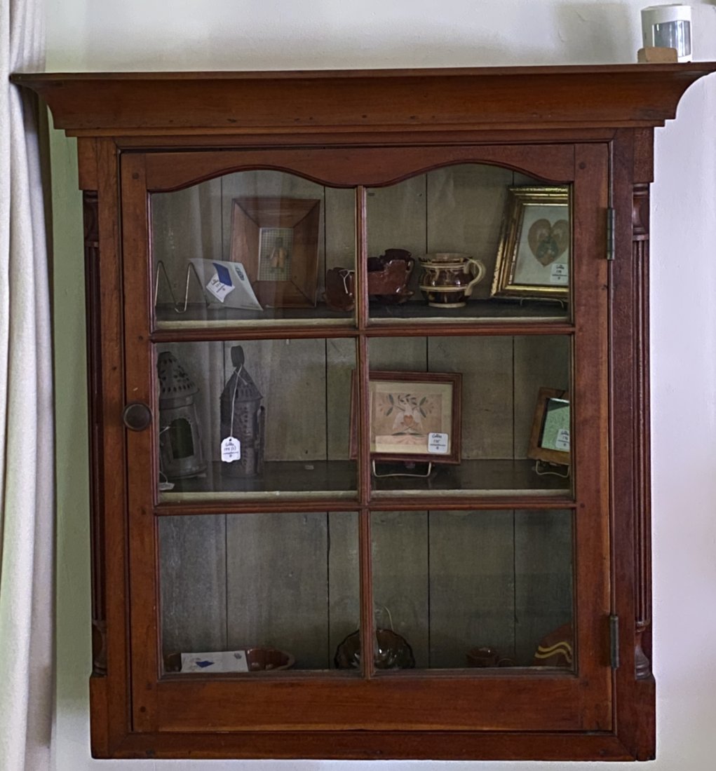 FEDERAL CHERRYWOOD HANGING CUPBOARD.: American, late 18th - early 19th Century. The molded cornice above a paneled six-light upper double arched door enclosing a two shelf interior, flanked by capped reeded quarter columns. 33.5"h. 33"w. 