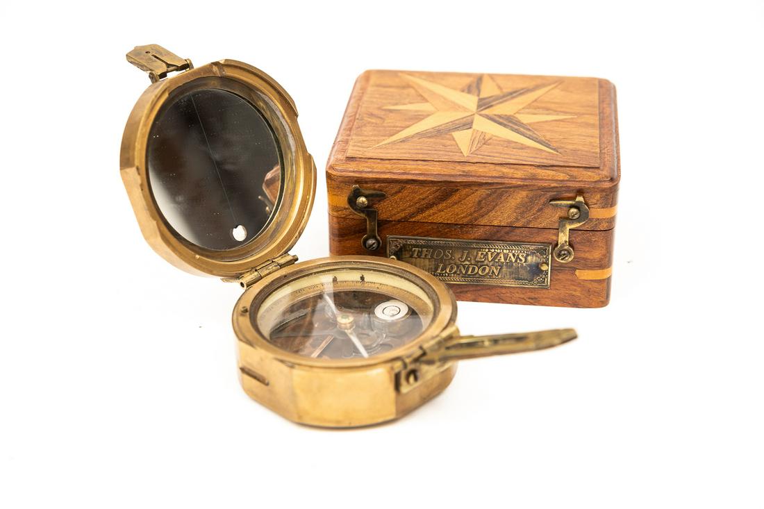 BRUNTON COMPASS BY THOMAS J. EVANS.: A brass Brunton compass by Thomas J. Evans, with "Makers to the Queen, London, 1920" on a copper plaque to the top. Presented in a wood marquetry box with brass label and latches. Good condition, some