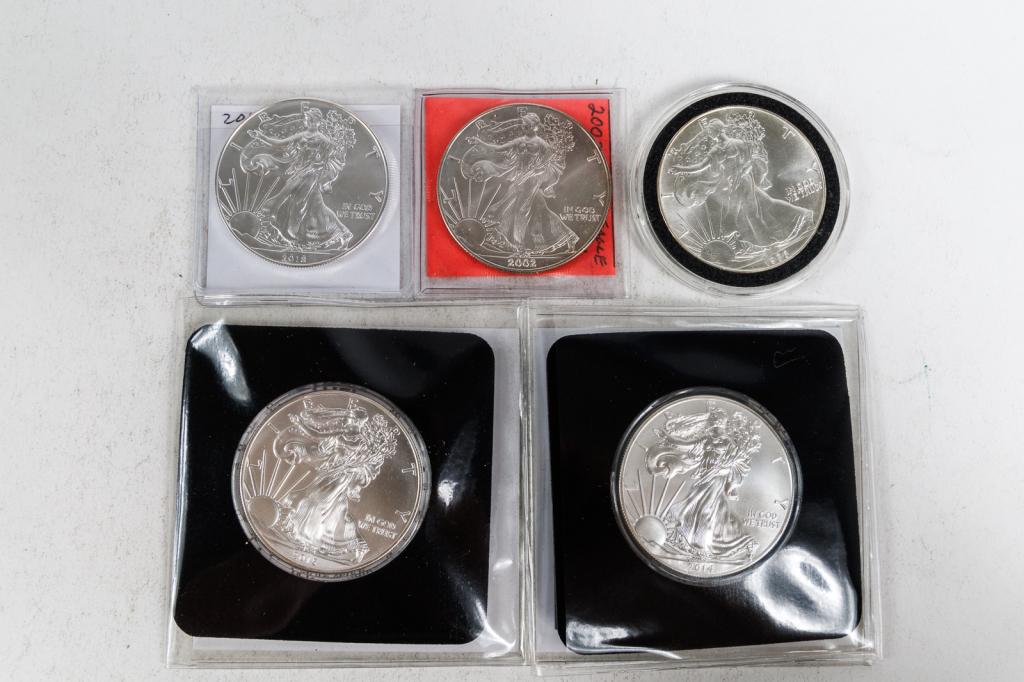 GROUP OF AMERICAN SILVER DOLLARS.: American, 21st Century. One 2014 Silver American Eagle Uncirculated $1 coin in case; One 2015 Silver American Eagle Uncirculated $1 coin in case; One 1986 Silver American Eagle $1 coin in case; One 20