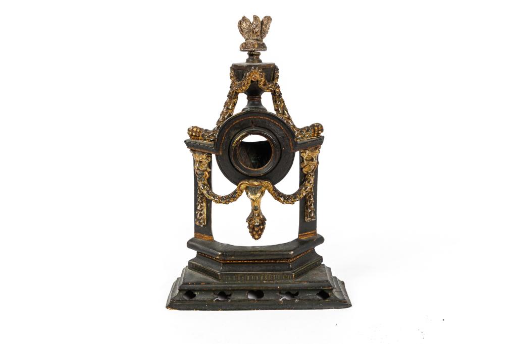 EARLY PAINT DECORATED WATCH HUTCH.: American, 19th Century. Circa 1800. Carved, gesso, gilded swags, tassels, lion and sheep-head ornamentation. Original surface and patina. Old museum accession label. 13”h.