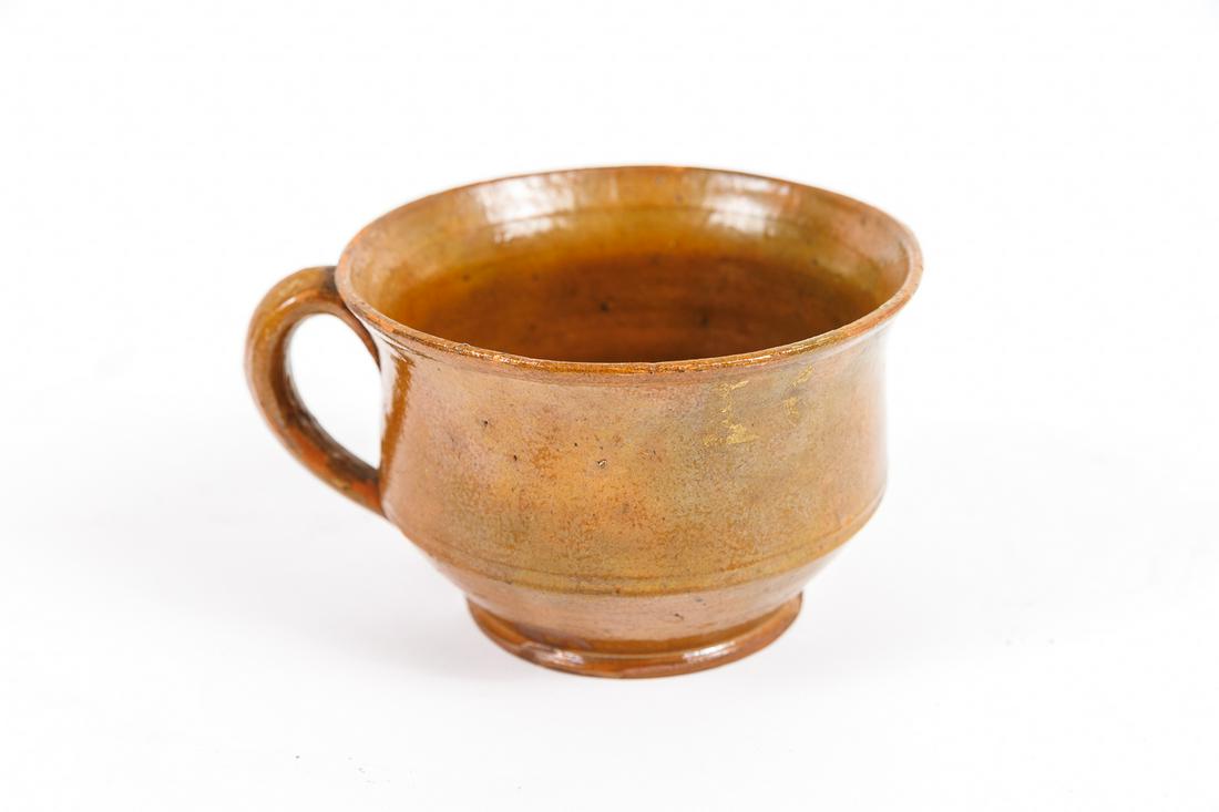 RED WARE CUP.: American, first half 19th Century. Red ware mush cup with a yellow and green glaze. 3.375"h x 4.75"d.