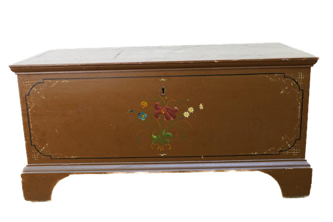 BLANKET BOX.: American (probably Pennsylvania), 19th Century. Dovetailed case with brown ground with black panel outlines and floral sprays. Cut-out feet. 44"l. 21.25"d. 21.5"h.