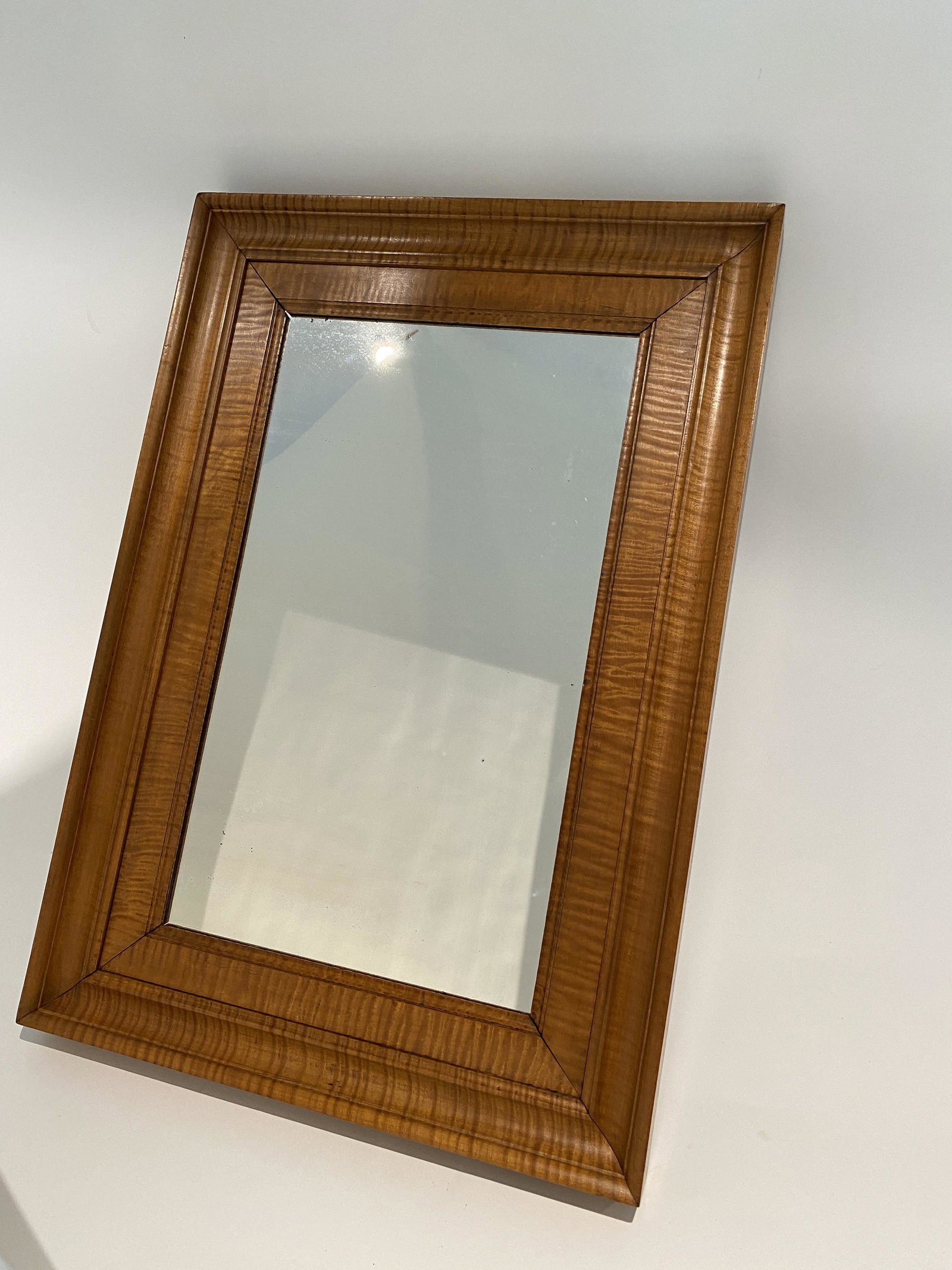 TIGER MAPLE MIRROR.: American (Pennsylvania), 20th Century. The frame measures 18.75" wide and 26.5" tall. The mirrored surface measures 11.5" x 19.5"