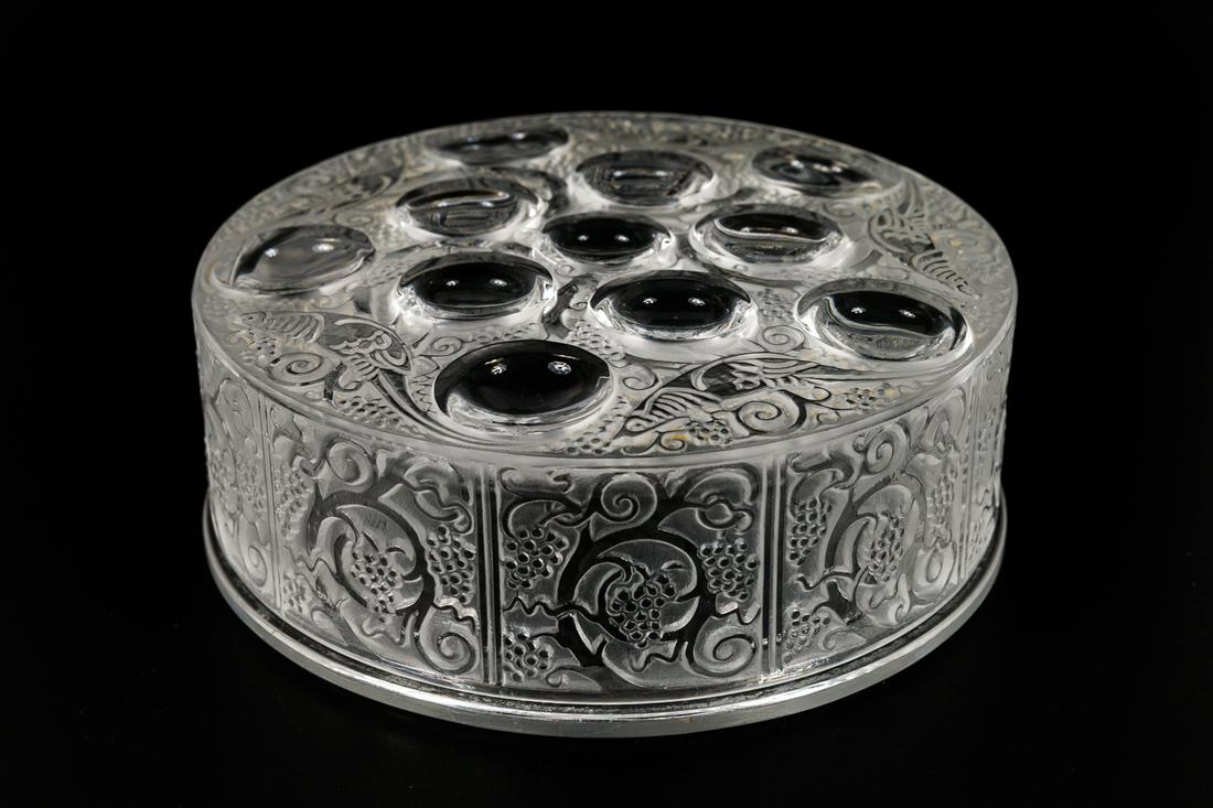 ART GLASS DRESSER BOX BY LALIQUE.: France, 20th Century. "Roger" powder puff box having 10 circles in five-point star pattern surrounded by stylized bird and scroll design. 1.875"h. 5.25"d.