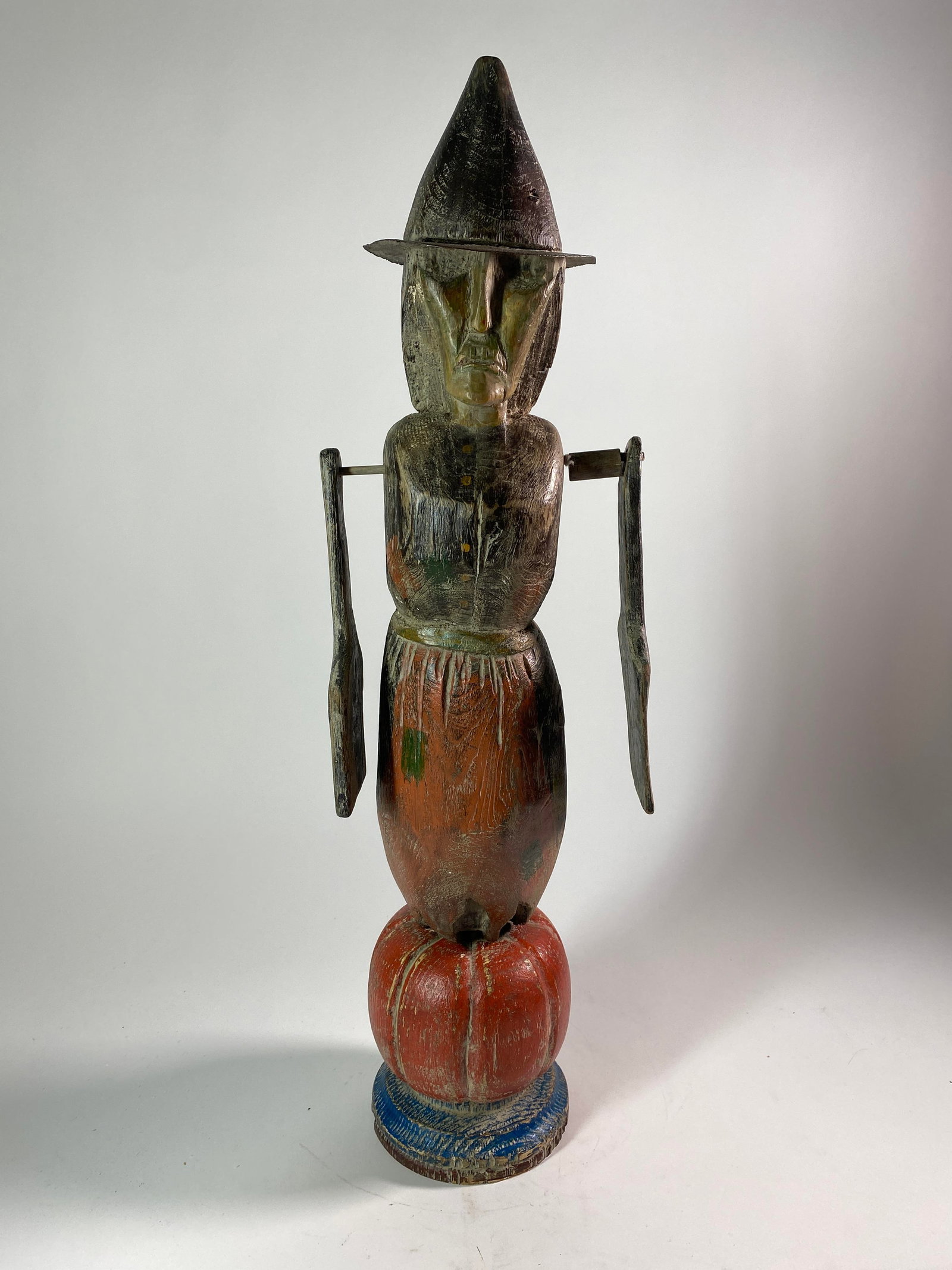 FOLK ART CARVED AND PAINTED HALLOWEEN-THEMED WHIRLIGIG BY P. "PAM" SCHIFFERL.: FOLK ART CARVED AND PAINTED HALLOWEEN-THEMED WHIRLIGIG BY P. "PAM" SCHIFFERL. American (Wisconsin), 20th - 21st Century. Wood, metal, and paint. Full-bodied witch figurine with hinged arms and hat sta