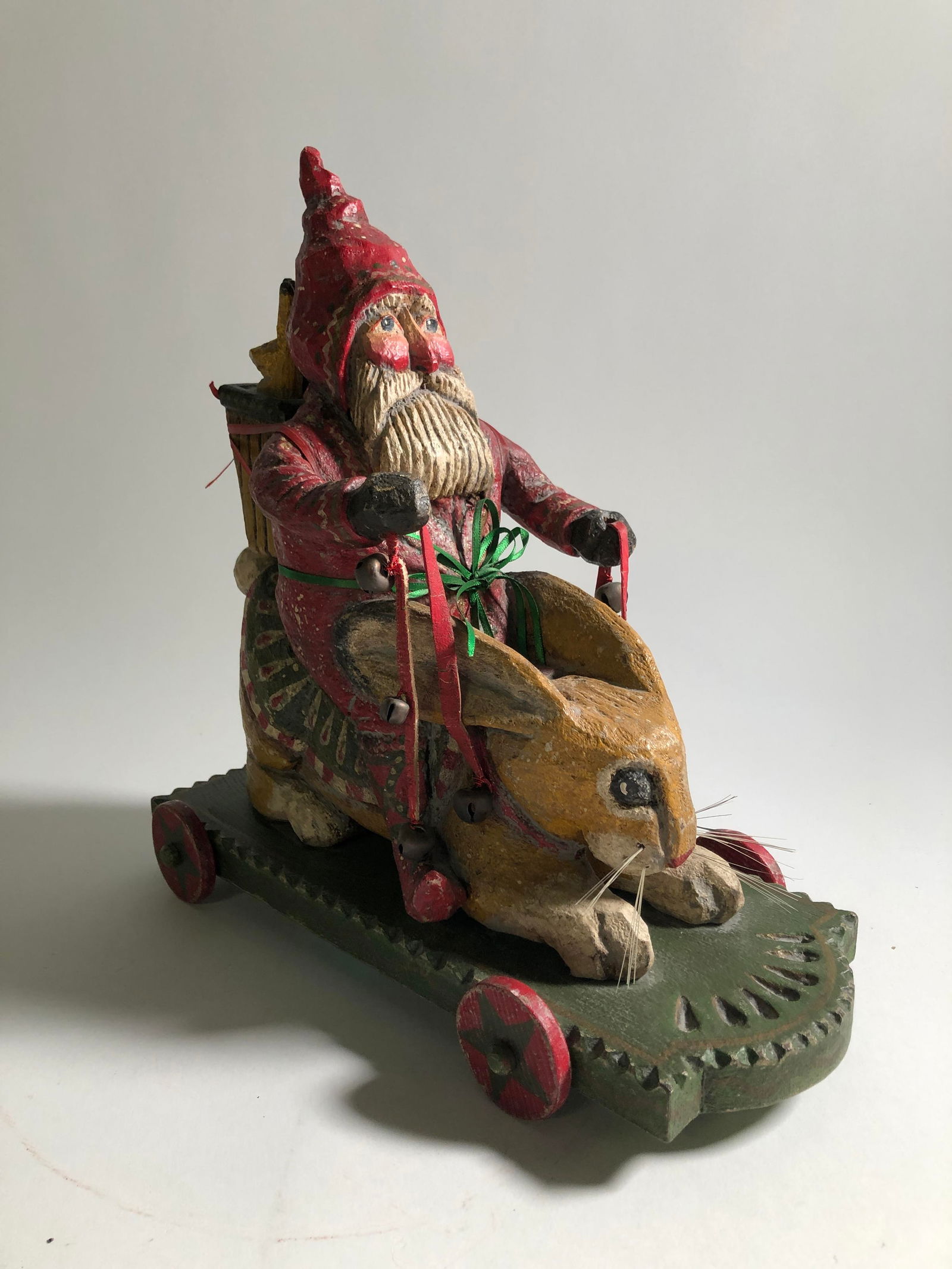 FOLK ART CHRISTMAS-THEMED CARVED AND PAINTED WOODEN TOY BY P. SCHIFFERL.: FOLK ART CHRISTMAS-THEMED CARVED AND PAINTED WOODEN TOY BY P. SCHIFFERL. American, 20th - 21st Century. Wood, paint, metal, and textile. Full-bodied Santa Claus (Father Christmas or St. Nicholas) on w
