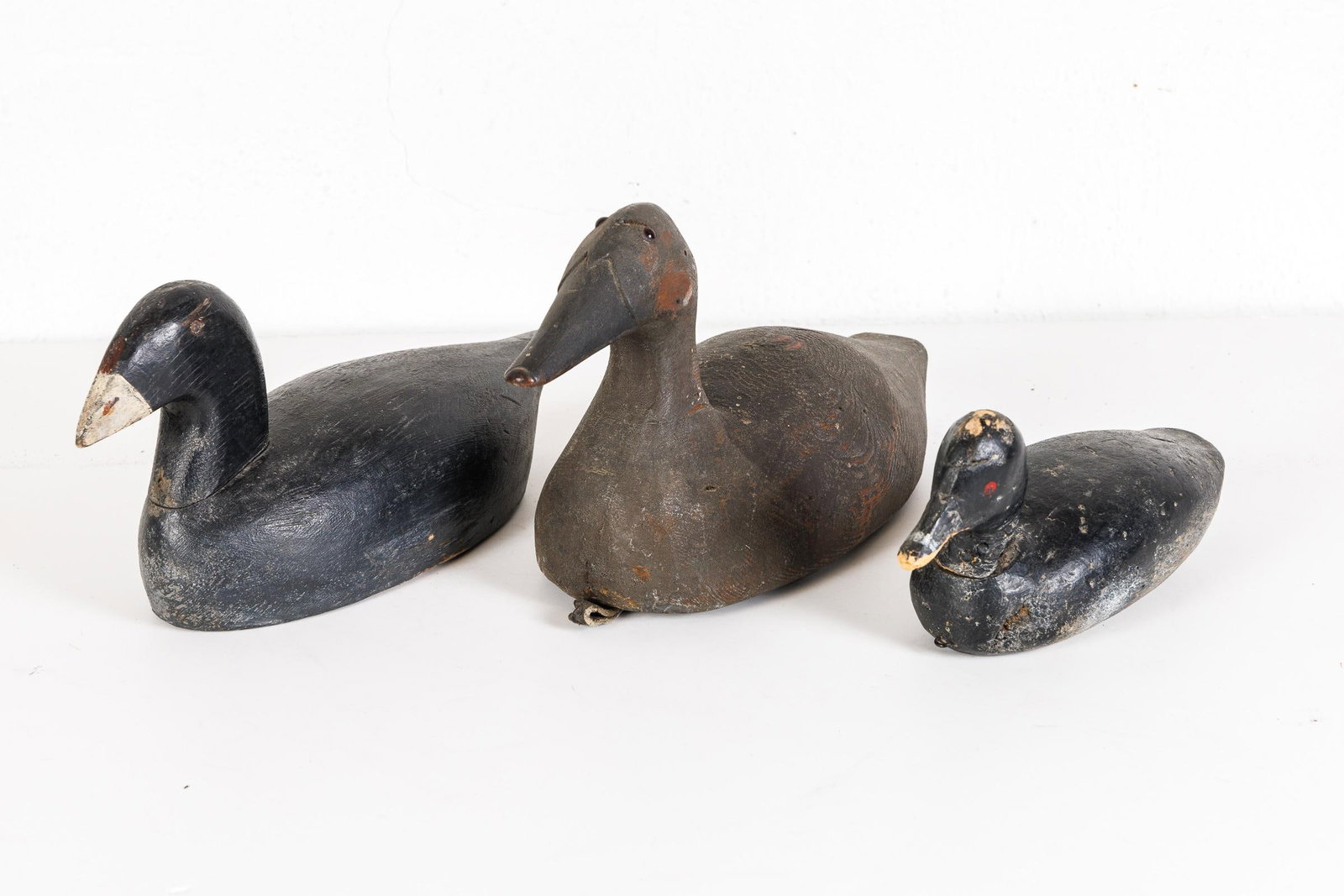 THREE CARVED AND PAINTED DECOYS.: American, 20th Century. Three functional decoys. One with glass eyes. 11"-15.5"l.