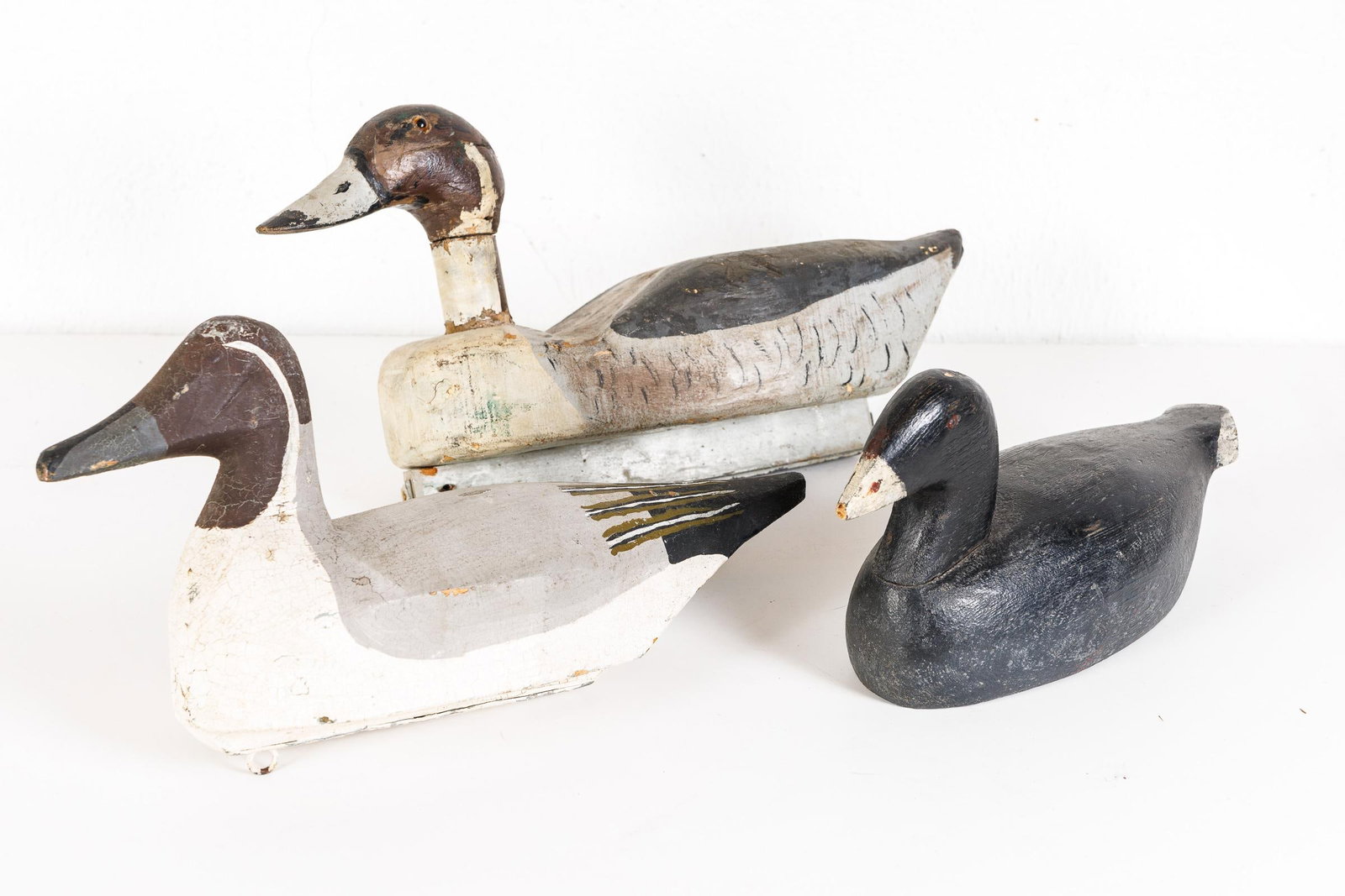 THREE CARVED AND PAINTED DECOYS.: American, 20th Century. Three functional decoys. One with glass eyes. 13"-16.5"l.