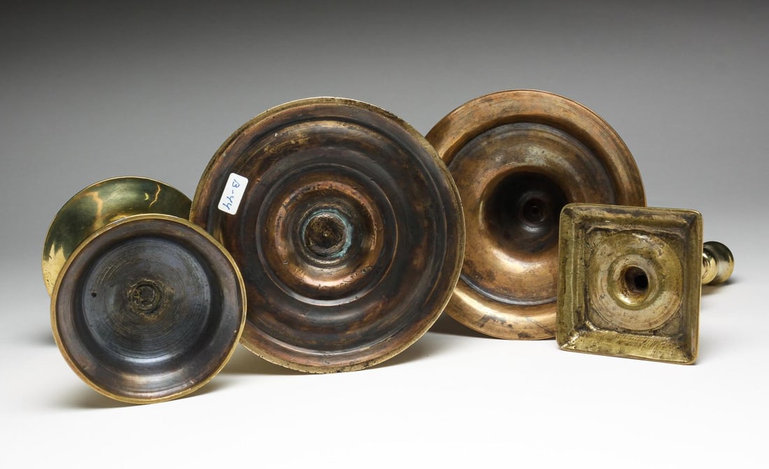 Four European Brass And Bell Metal Candlesticks. Auction