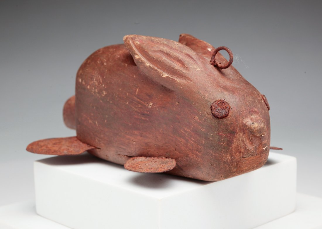 RABBIT ICE FISHING DECOY.: American, fourth quarter 20th century. Naive carving with original paint and distressed tin feet. 6"l.