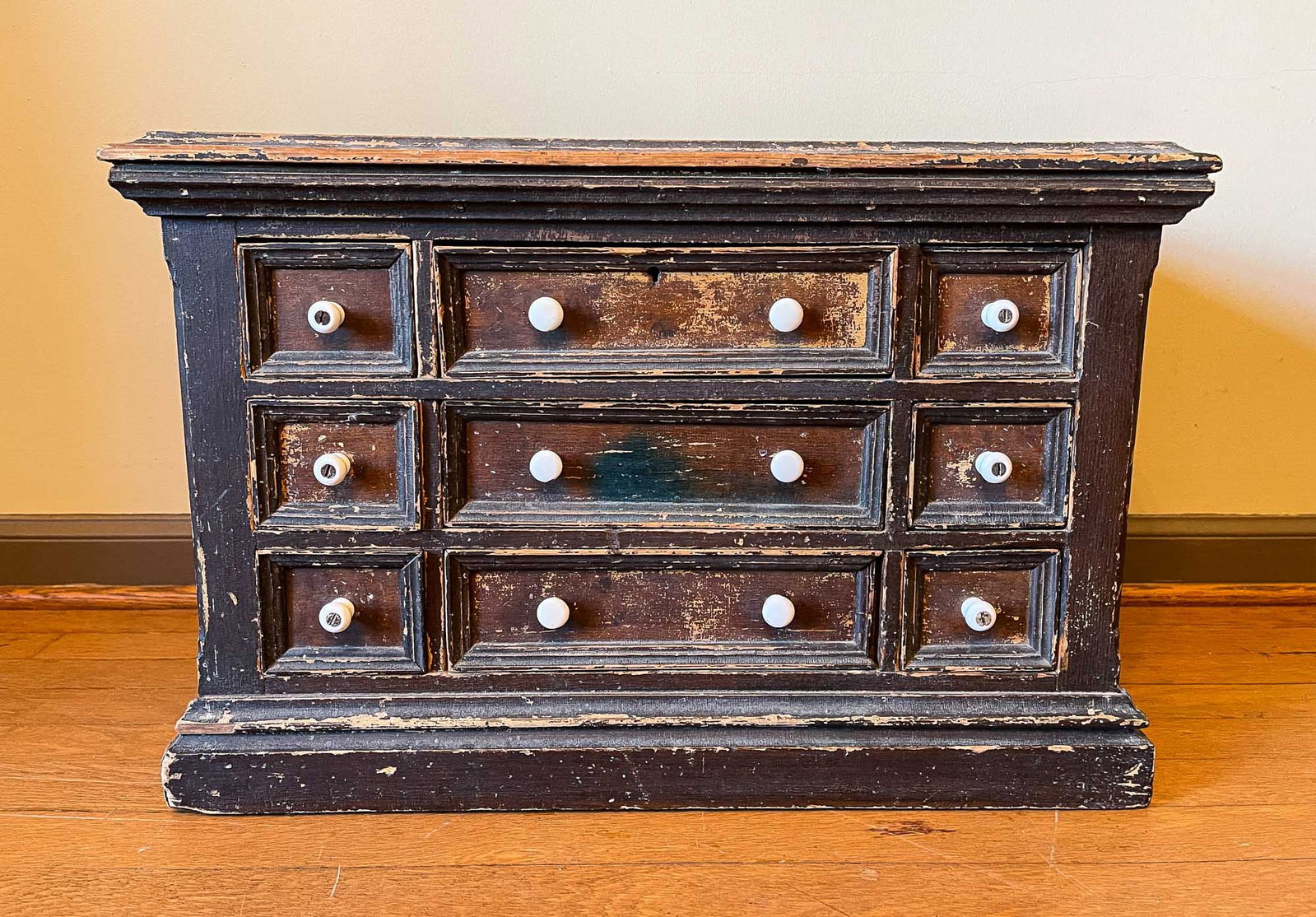 VICTORIAN PAINTED CASE OF DRAWERS.: Third quarter 19th Century. Pine. Top with routed edge, cornice and base moldings. Paneled ends, lambs tongue chamfered corners and drawers with applied molding on fronts. Original worn brown and tan 