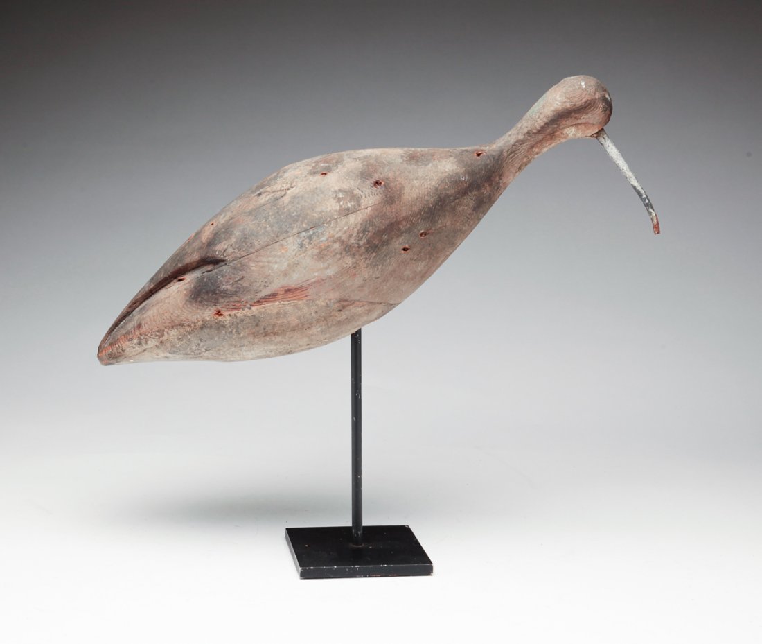 CARVED PLOVER SHOREBIRD.: American, first quarter 20th century. Stylized form with wrought iron nail beak and worn original paint. Shot scars. 11.25"h. 13"l. including base.