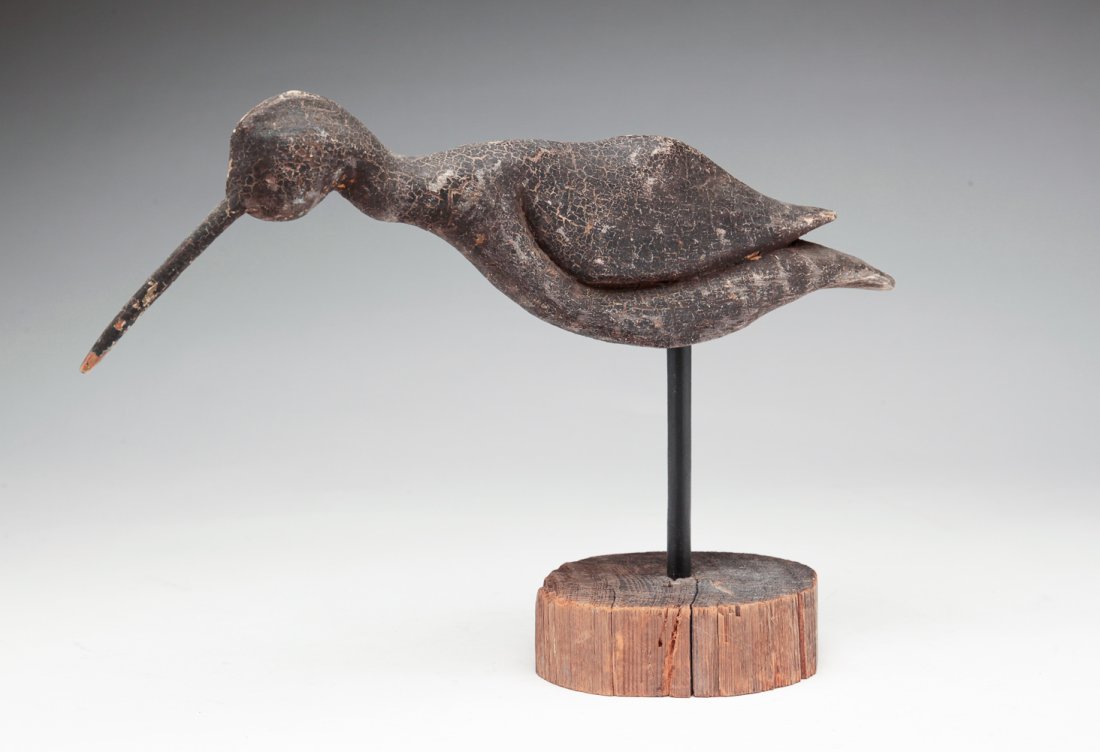 FOLKSY CARVED SHOREBIRD.: American, first half 20th century. Original black paint, carved beak. Dry surface with light alligatoring. Some wear. 7.25"h. 11"l.