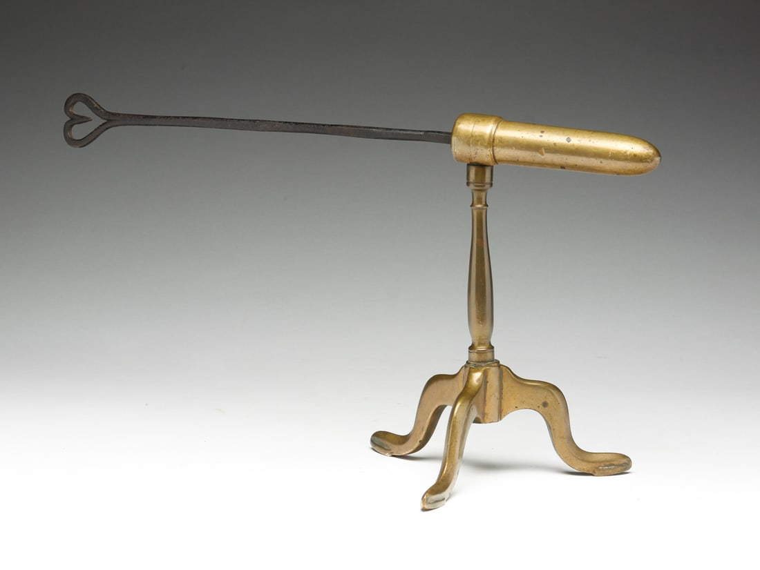 BRASS GOFFERING IRON.: American or English, mid 19th Century. Brass holder on tripod base and wrought iron iron with heart shaped handle. 8.5"h. 15.5"l.