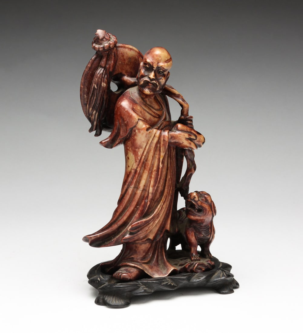 CHINESE SOAPSTONE CARVING OF SCHOLAR.: China, 20th Century. Robed figure with staff and foo dog. 6"h.