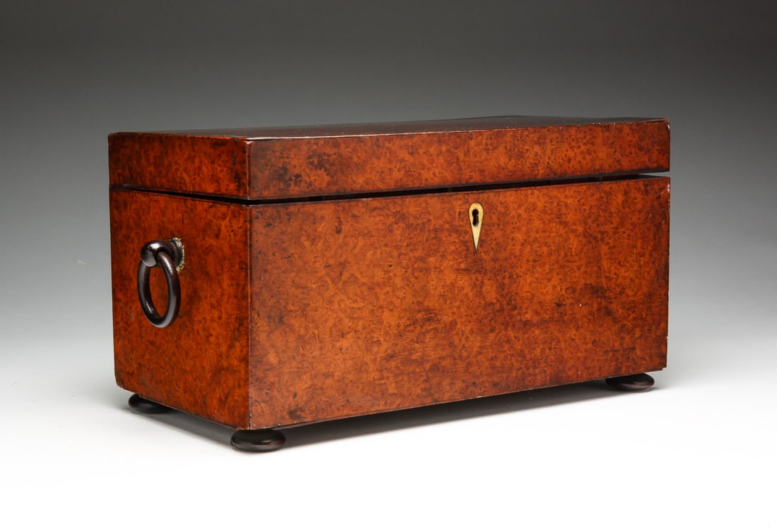 TEA CADDY.: American or England, 1st half 19th Century, burl veneer. Ebonized button feet, and ring handles. Cloth lined interior has two compartments with worn foil lining, and replaced glass mixing bowl. Refini