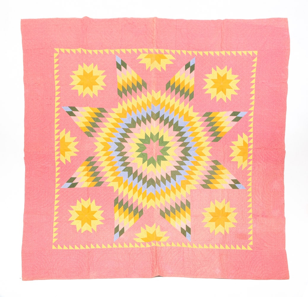 PIECED QUILT.: American, late 19th Century. "Sun with Satellites" patterned quilt. On patterned field with sun made from various fabrics in solids and patterns. Bright yellow border. 82" x 83".