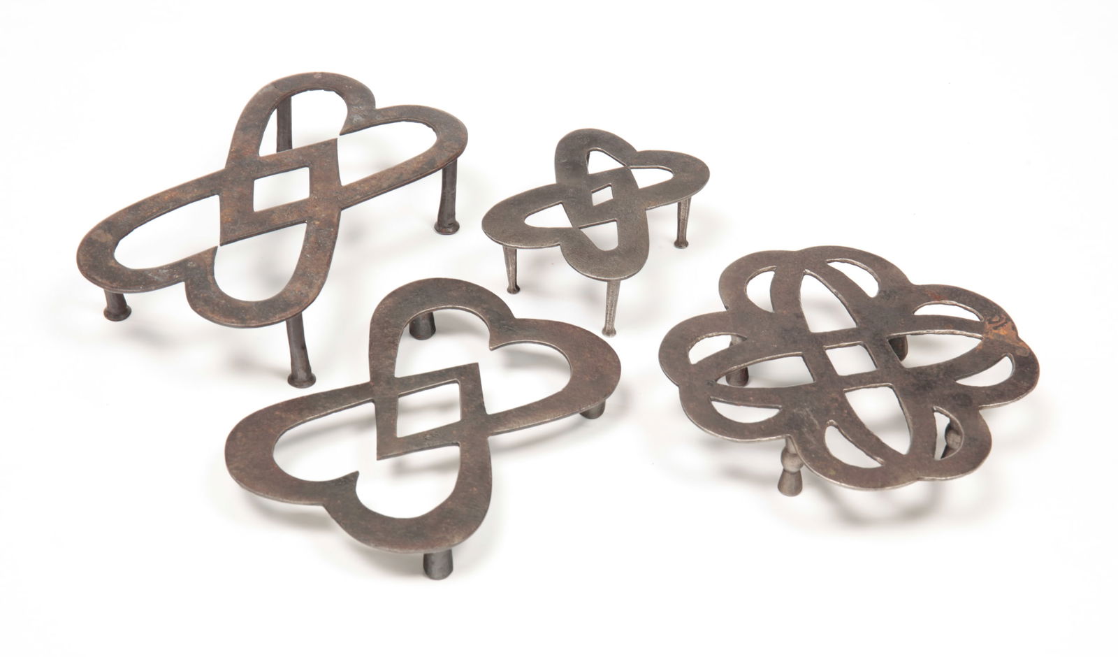 FOUR WROUGHT IRON TRIVETS. (1 of 3)
