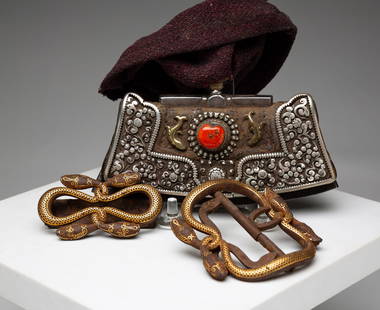 ASIAN BELT HOOK AND TIBETAN TINDER POUCH.: Twentieth Century. Early leather and silver pouch with steel edge and coral stone. Covered with purple felt. Wear, 3.5"h. 5.5"w. Together with inlaid iron belt hook and loop in the form of snakes. Loo