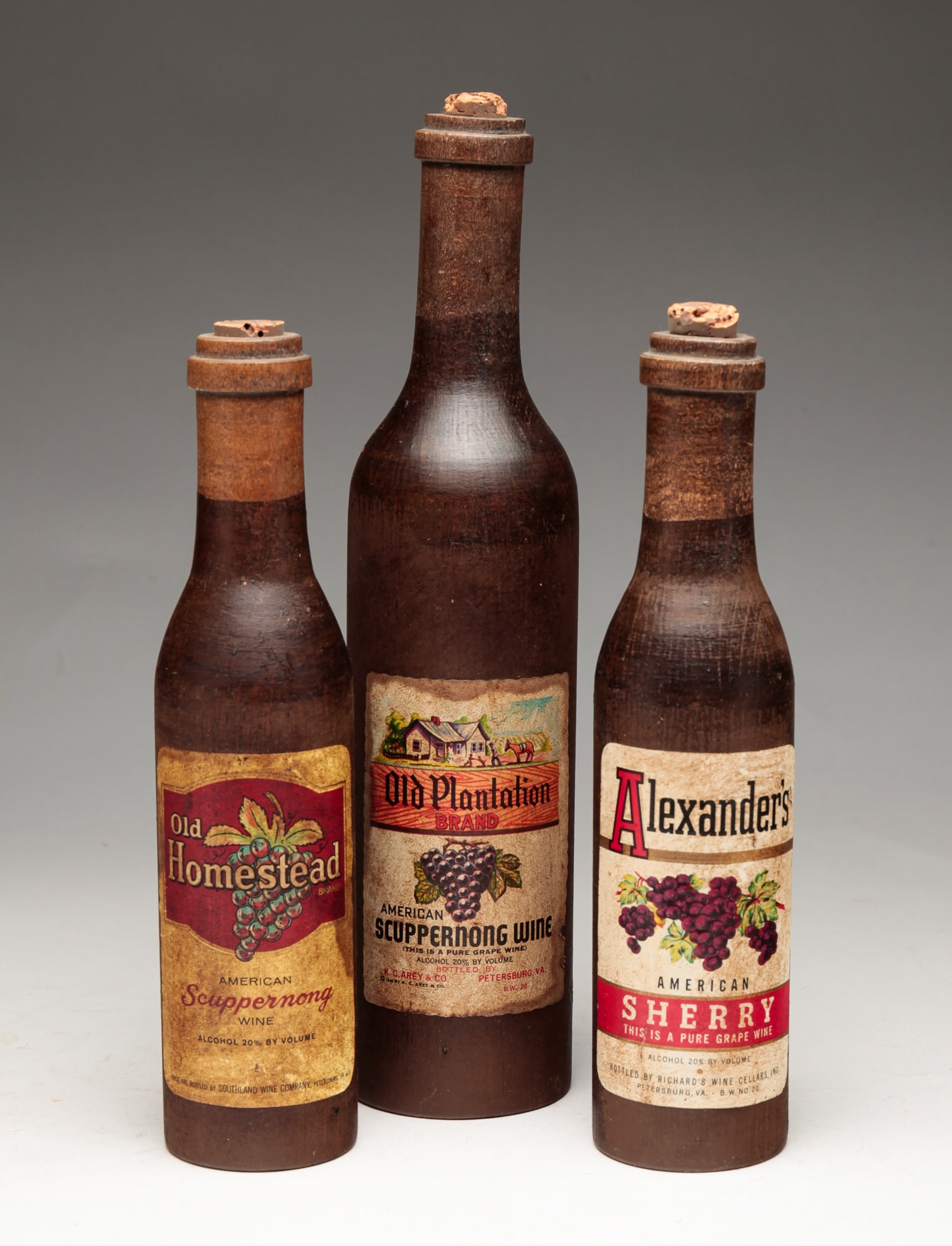 WOODEN ADVERTISING WINE BOTTLES.: American, (Petersburg, Virginia). Three advertising bottles. Sherry bottle, 9.5"h, Scuppernong wine bottle, 9.5"h, and wine bottle, 12"h.