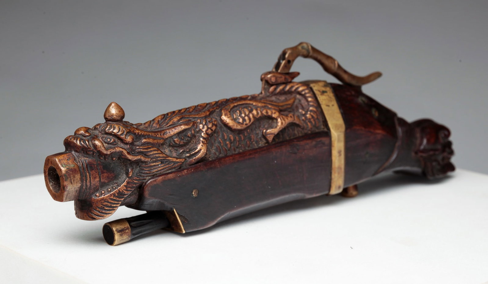 MATCH LOCK PISTOL.: Chinese, second half 19th Century. Dragon cast bronze barrel, teak stock with carved dragon head butt and brass fittings and hardware. 7"l.