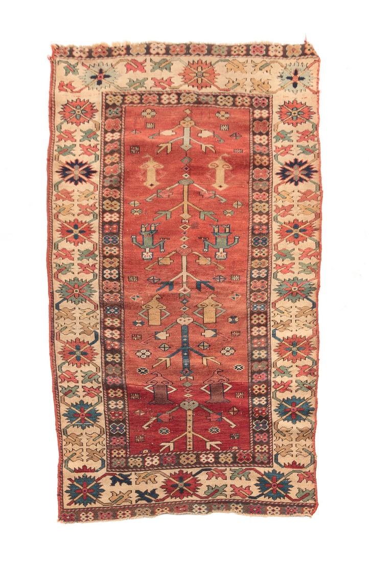 CAUCASIAN FIGURAL RUG.: First quarter 20th century. Wide ivory border, abrash salmon red ground. Wear, edge loss. 2'10" x 5'4".