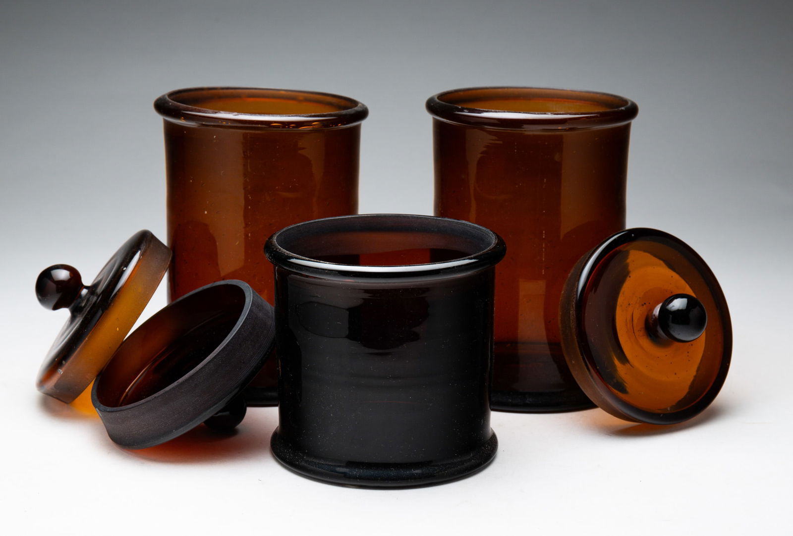 THREE BLOWN AMBER GLASS JARS. (1 of 3)