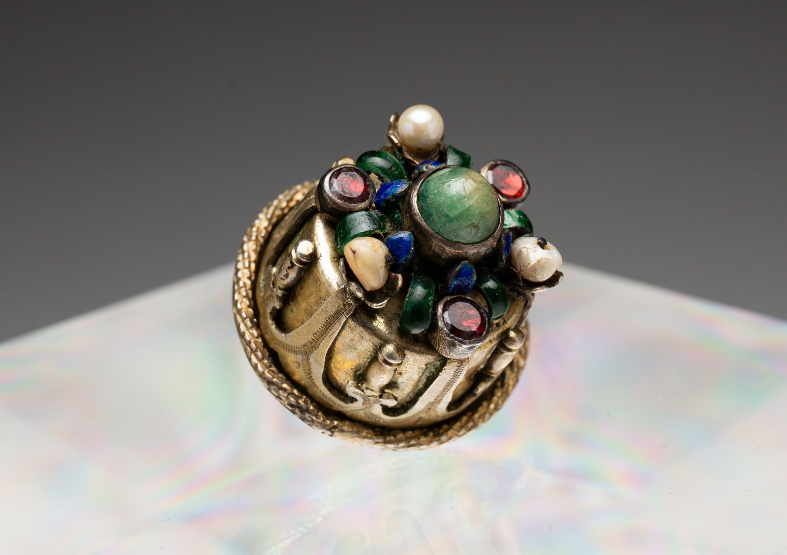 SMUGGLERS BUTTON.: European, 17th Century. Cylindrical button with enamel and colored stone accents, possibly garnets, pearl and turquoise. Center stone unscrews to open the button. .75"dia. 1"h (including shank).