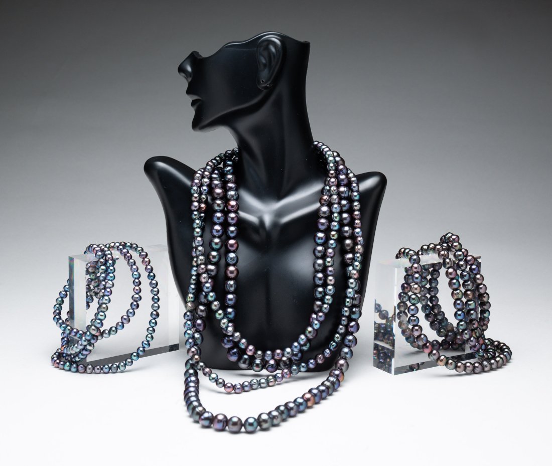 FOUR STRANDS CULTURED TAHITIAN PEARLS.: Early 21st century. Four continuous strands dark gray/black pearls with purple, blue and green overtones, semi- round and semi-baroque, not knotted, good luster, moderately spotted, circled. Strands a