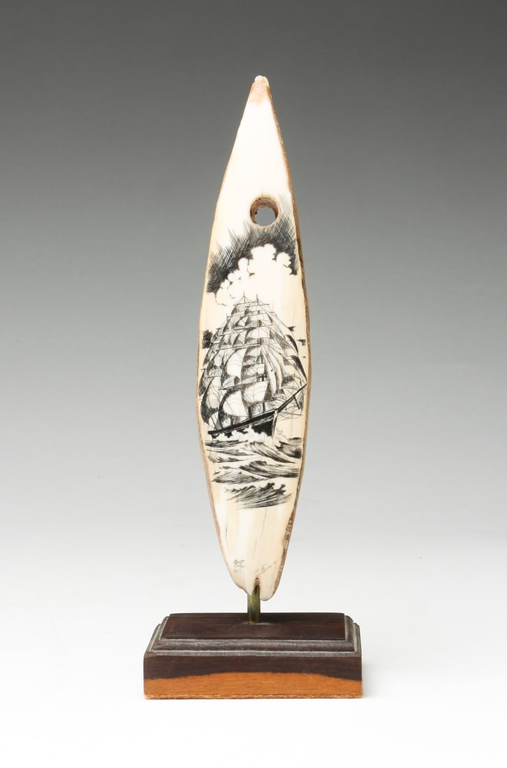 SCOTT PARKER DECORATED SCRIMSHAW ON STAND.: American, dated 1981. Fossilized whale scrimshaw on stand. Decorated with clipper ship at sea. Attached to stand. 7.25"h.