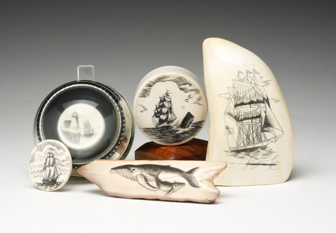 FIVE PIECES OF DECORATED SCRIMSHAW.: American, contemporary. Includes tooth with clipper ship decoration, wear to edges, 4.25"h. Fossilized piece with whale decoration, 4.25"l. Paperweight with decorated chip, 3"w. Round lidded trinket b