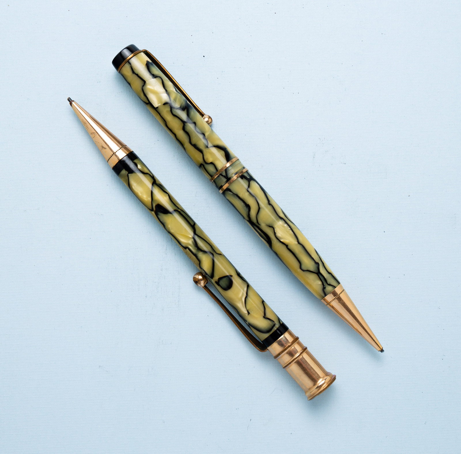 PAIR OF VINTAGE PARKER PENCILS.: American, circa 1930s. Matching pair of mechanical pencils in black and pearl. One is a Senior Duofold Moderne and is missing the middle gold band. The other is a Senior Duofold in good condition. Bot