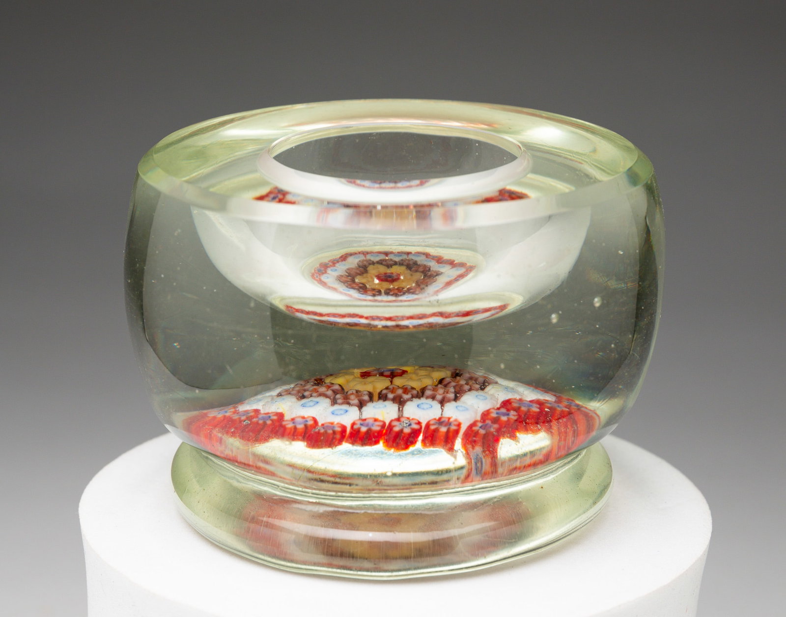 PAPERWEIGHT INKWELL.: Probably English, first half 20th Century. Millefiore decoration in reds, blues and whites. Glass body has slightly yellow tinge. 2.25"h. From the collection of the late Audrey Caspari (New Jersey).
