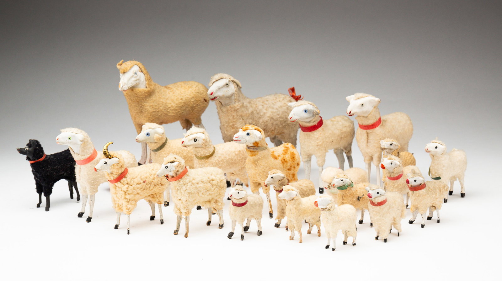GROUP OF TOY LAMBS.: American (Pennsylvania) or German, circa 1900. Impressive collection of 22 toy sheep with black hooves (Christmas). Largest is on wheels, 6"l. 5.5"w.