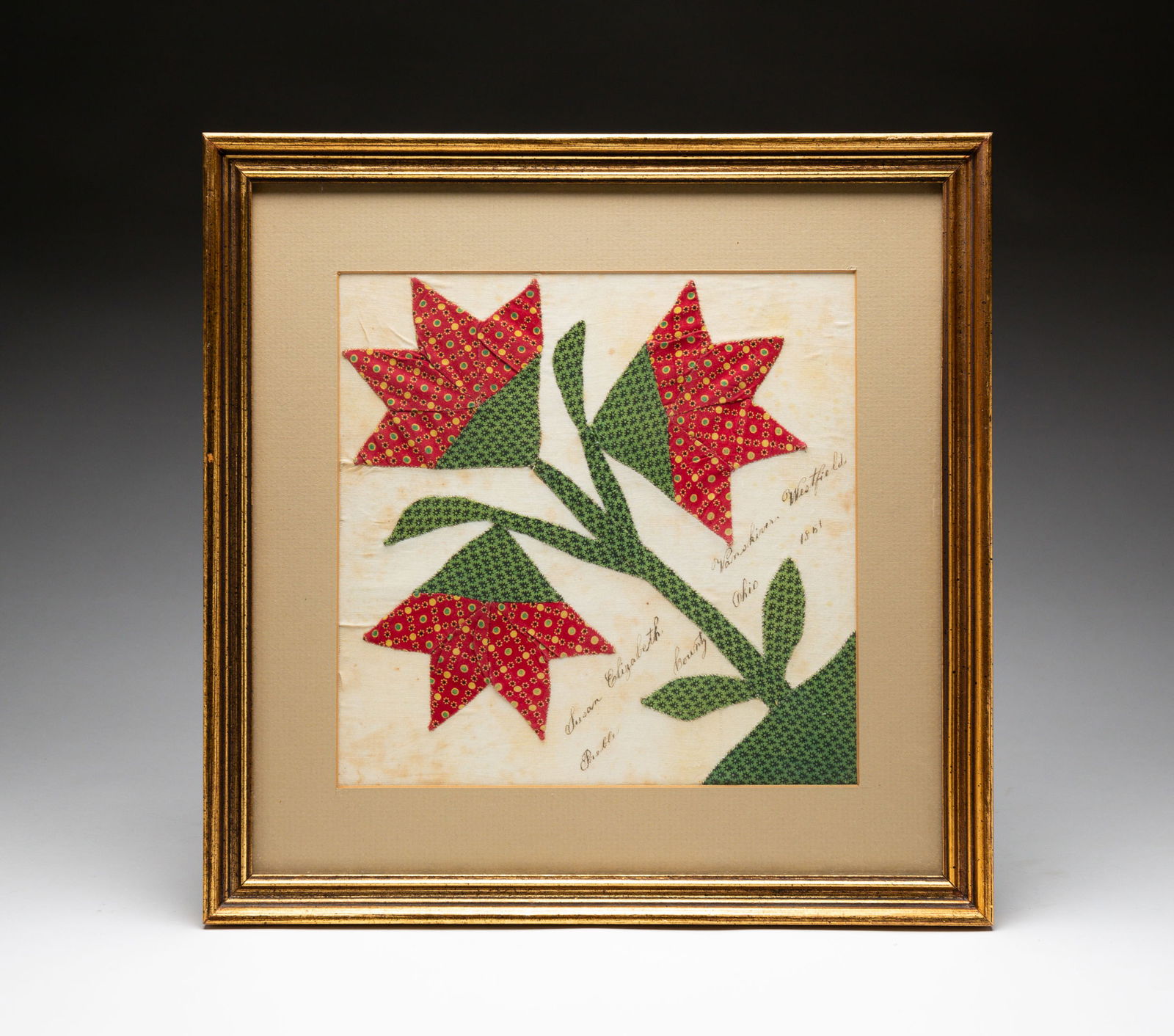 FRAMED OHIO QUILT SQUARE.: Mid 19th Century. Cotton. An applique three bloom tulip in patterned fabrics inscribed in black ink "Susan Elizabeth Vanskiver, Westfield, Preble County, Ohio 1851". Some toning to white fabric. Frame