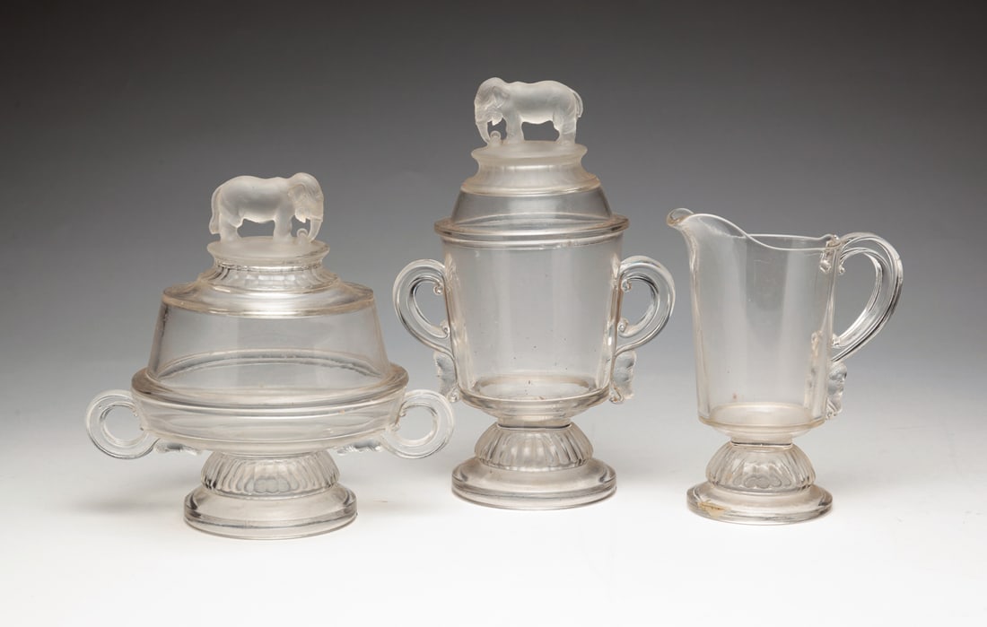 THREE PIECES OF "JUMBO" PATTERN GLASS.: American, late 19th Century. Canton Glass Company. A creamer 6.5 "h, a lidded sugar, chip on tail, 9.25 "h and a covered butter dish. 7 "h.