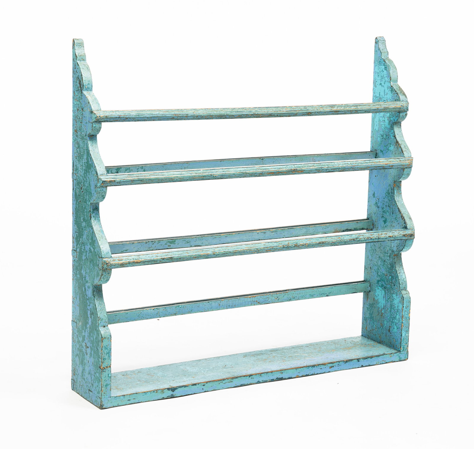 PAINTED PLATE RACK.: American, circa 1800. Dovetailed frame, scalloped ends, three grooved rails and layered paint over original dark green. 33"h. 35"w. 6.75"d. From the collection of the late Audrey Caspari (New Jersey).