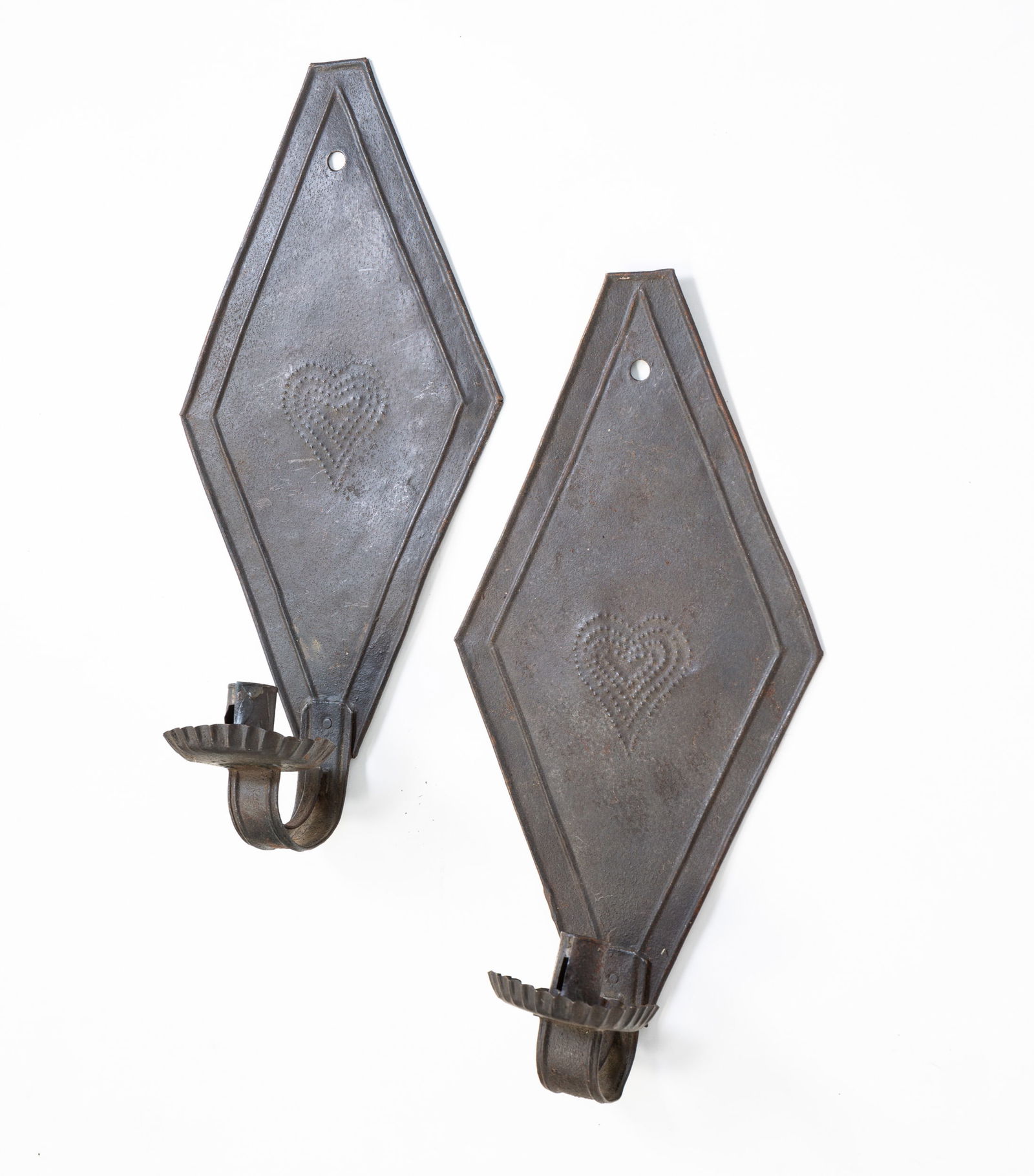PAIR OF TIN WALL SCONCES.: American, 19th Century. Pair of tin diamond-back wall sconces with punched hearts and crimped drip cups. 16.5"h. From the collection of the late Audrey Caspari (New Jersey).